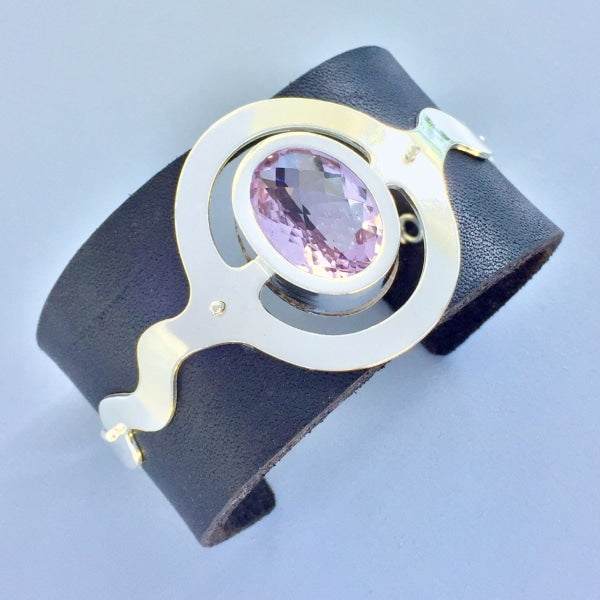LEATHER AND SILVER CUFF BRACELET WITH CHECKERED AMETHYST | <Z-FIRE.COM> This gorgeous and lovingly handcrafted bracelet cuff holds a unique and beautiful checkerboard oval cut amethyst that is set in a .999 pure Fine Silver cuff. The cuff is mounted ontop a 1.5 " wide black leather. 1.5" Wide Leather Bracelet  .999 Fine Silver Cuff  Checkerboard Cut Amethyst Free Astrological Report Free standard shipping Hassle Free Returns  