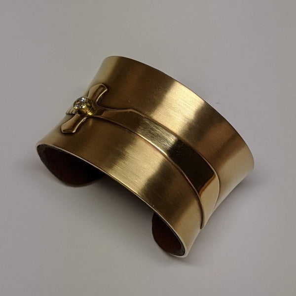 CUFF BRACELET WITH SWORD | <Z-FIRE.COM> This uniquely handcrafted brass bracelet is padded with leather on the inside.  Let the symbol of the sword be a reminder of the power of your words. Use them with authority to cut through any lies coming in either through your mind or directed towards you. 1.25" Wide Brass Cuff Padded With ♻️ Brown Leather on the Inside Free Astrological Report Free Standard Shipping Hassle-Free Returns