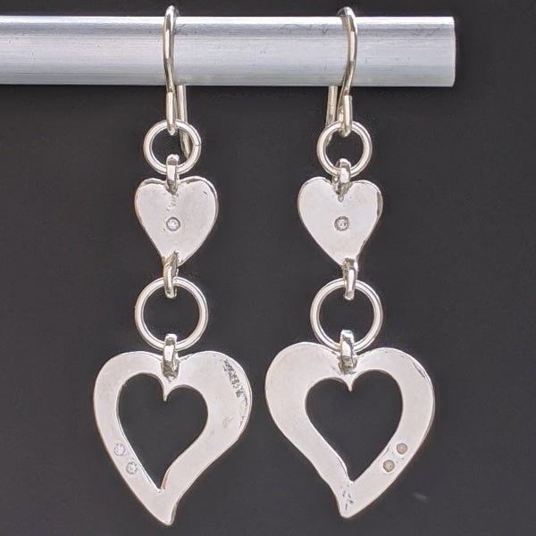 DOUBLE HEART CHAKRA FINE SILVER DANGLE EARRINGS | <Z-FIRE.COM> Stay in your true alignment with the help of Free Standard Shipping Free Astrological Report of Choice Hassle Free Returns .999 Fine Silver Hearts .925 Sterling Silver Kidney Wires 0.5 Inches wide 1.5 cm wide About 1 Inch Total Length 3 cm Total Length Hassle Free Returns
