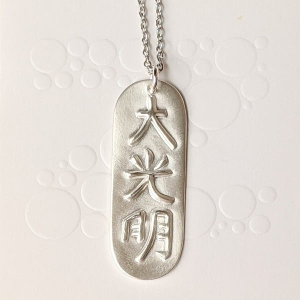 FROSTED DAI-KO-MYO PENDANT | < Z-FFIRE.COM > The Master Reiki Symbol Dai Ko Myo can help balance out energies carried through inherited memory and work on cellular levels. The Dai Ko Myo symbol is composed of three kanji's or characters and has the meaning of "great bright light" or "great shining light." The symbol represents empowerment: intuition, creativity, and spiritual connection.  .950 Pure Silver Dai Ko Myo Pendant 1.5" Length 0.5" Width < 4 cm Length < 1.5 cm Width