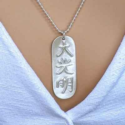 FROSTED DAI-KO-MYO PENDANT | < Z-FFIRE.COM > The Master Reiki Symbol Dai Ko Myo can help balance out energies carried through inherited memory and work on cellular levels. The Dai Ko Myo symbol is composed of three kanji's or characters and has the meaning of "great bright light" or "great shining light." The symbol represents empowerment: intuition, creativity, and spiritual connection. .950 Pure Silver Dai Ko Myo Pendant 1.5" Length 0.5" Width < 4 cm Length < 1.5 cm Width